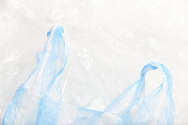 Blue and white striped plastic single use bag, wrinkled background. Concepts: sustainability, recycling, pollution.