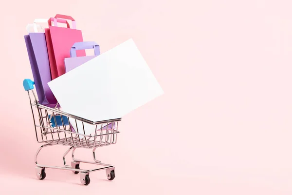 Shopping Cart Loaded Paper Bags Blank Card Pastel Pink Background — Stock fotografie