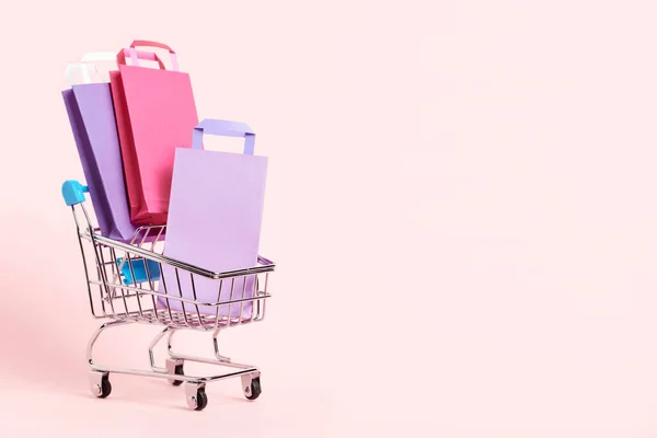 Shopping Cart Loaded Paper Bags Pastel Pink Background Minimalist Design — Stock fotografie