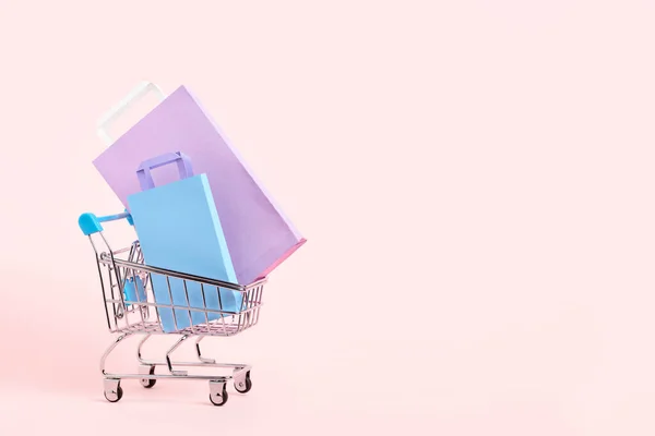 Shopping Cart Purple Lilac Blue Paper Bags Pastel Pink Background — Stock fotografie