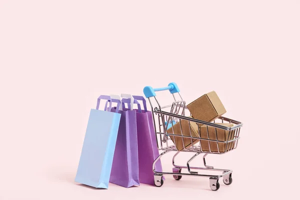 Shopping Cart Cardboard Boxes Paper Bags Pastel Pink Background Simple — Stock fotografie