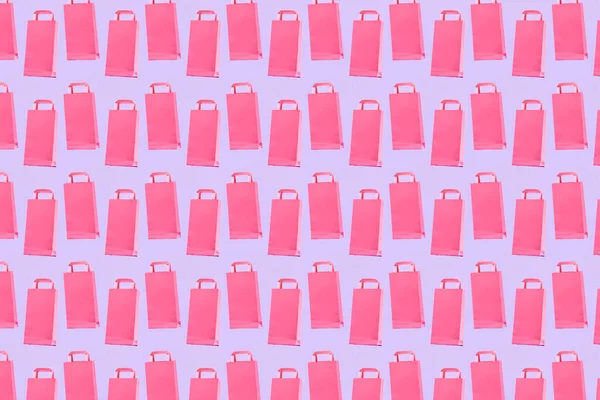 Alışveriş konsepti, pastel renk deseni, leylak arka planda pembe renkli kese kağıtları..