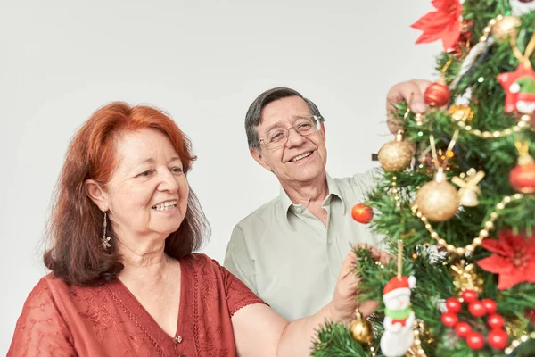 Happy Latin Senior Couple Smiling While Decorating Traditional Christmas Tree — Stock Photo, Image