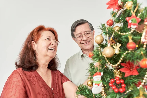 Happy Hispanic Senior Couple Smiling While Decorating Traditional Christmas Tree — Stock Photo, Image