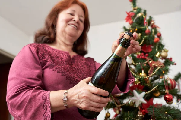 Latin Olgun Bir Kadın Arkada Noel Ağacı Olan Bir Şişe — Stok fotoğraf
