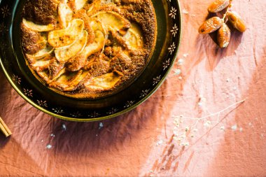 Altın tepside sunulan elmalı kekin üstüne konan doğal ışık.