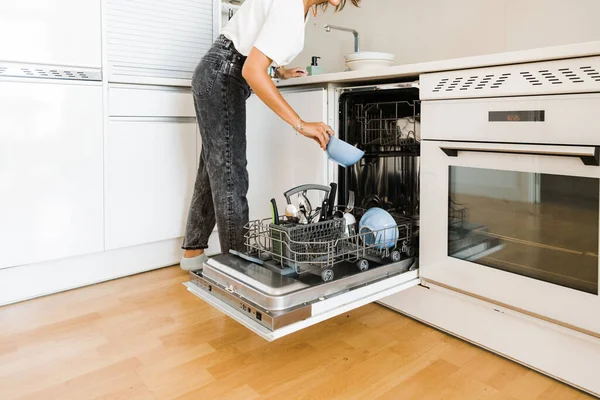 Young unrecognizable woman putting the dishes in the dishwasher — 스톡 사진