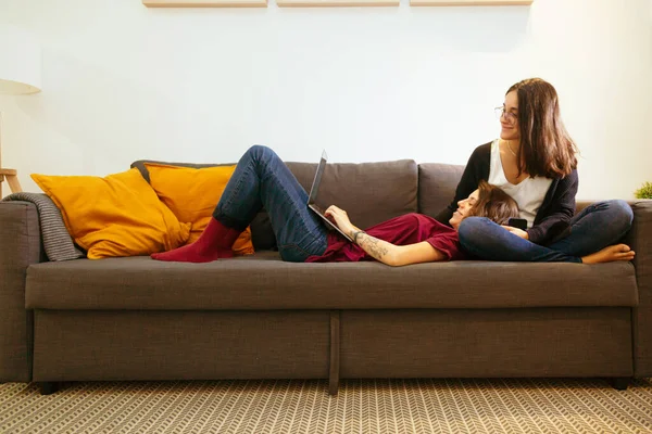 Лесбийская пара на диване с ноутбуком — стоковое фото