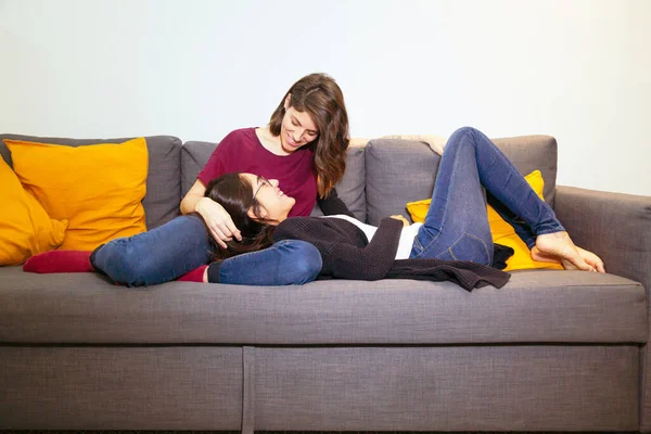 Happy lesbian couple in love cuddling on the sofa — Stock Photo, Image