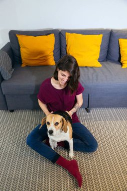 Oturma odasında köpeğiyle mutlu bir kadın.