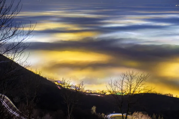 As luzes artificiais do Vale do Pó se espalharam por um denso nevoeiro. Província de Vicenza, Itália — Fotografia de Stock