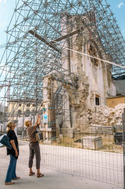 2016 depreminde yıkılan bir kiliseye benzeyen iki kişi var. Norcia, İtalya