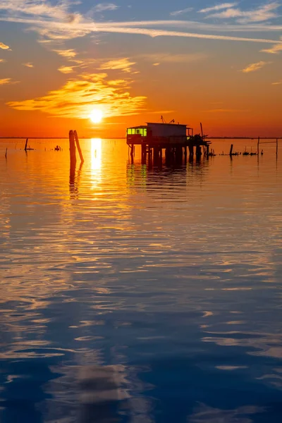 Pôr do sol na lagoa veneziana com as casas de pescadores, ilha de Pellestrina, lagoa veneziana, Itália — Fotografia de Stock