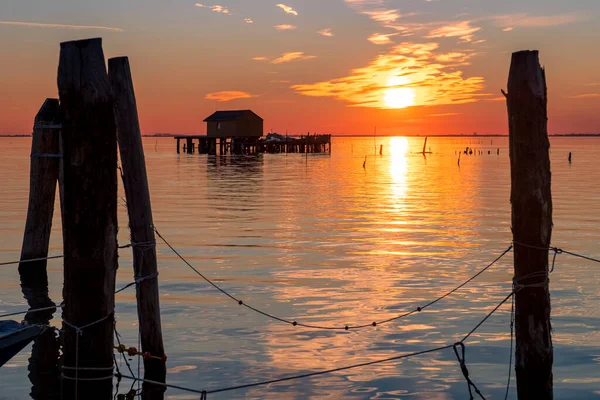 Pôr do sol na lagoa veneziana com as casas de pescadores, ilha de Pellestrina, lagoa veneziana, Itália — Fotografia de Stock