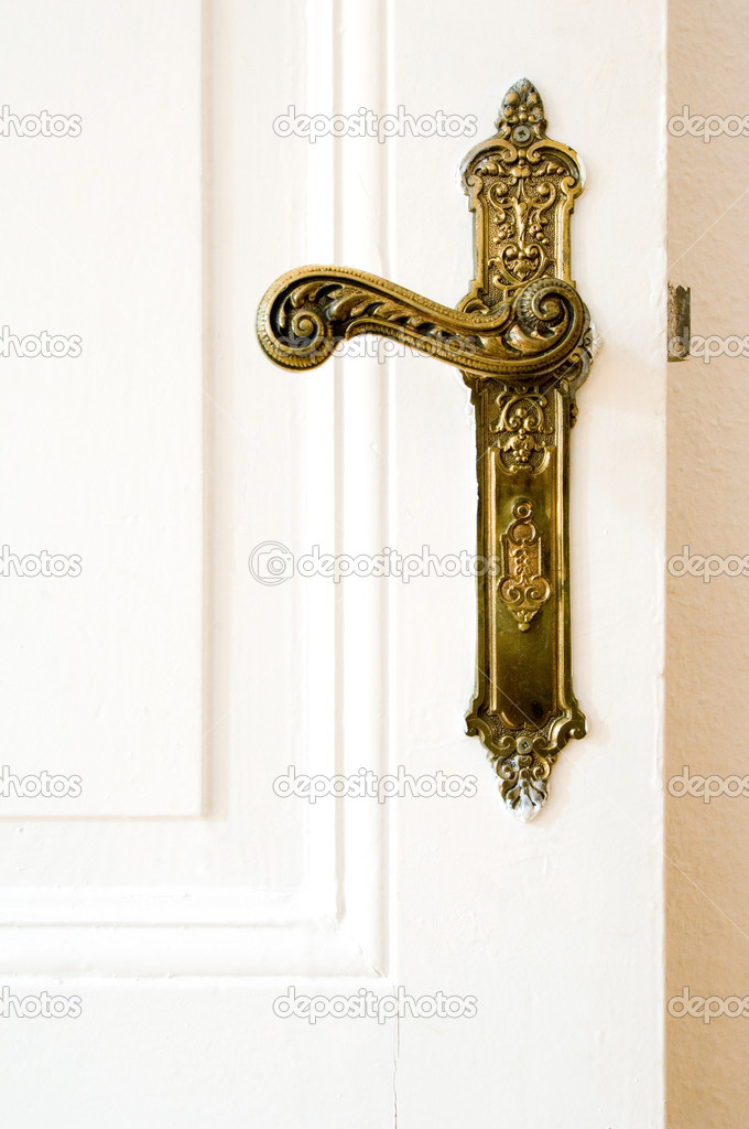 Old, ornate door handle on white door