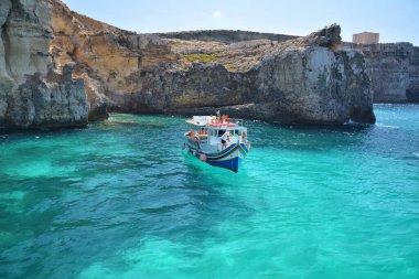 Comino, Malta - 24 Ağustos 2020 - Malta 'nın Comino adasındaki Crystal lagoon körfezinde turist botu.