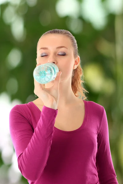 Junge schöne Frau mit Flasche Wasser — Stockfoto