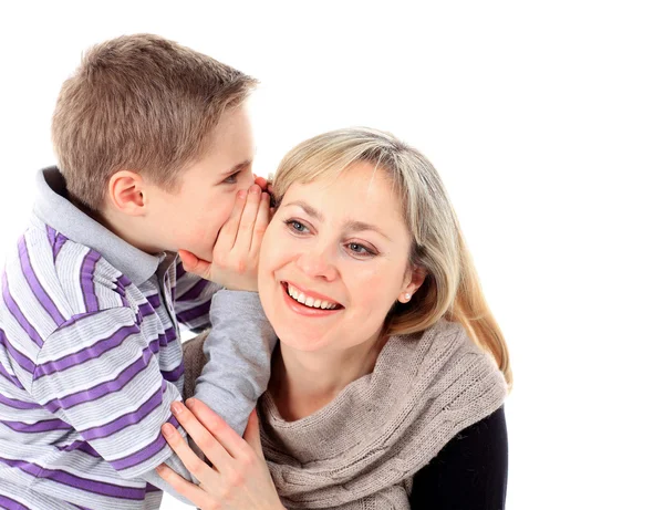 Um rapaz está a sussurrar um segredo no ouvido das mães. Fotografias De Stock Royalty-Free