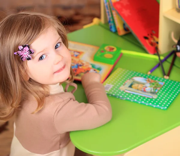 Schönes kleines Mädchen liest Märchen am Tisch — Stockfoto