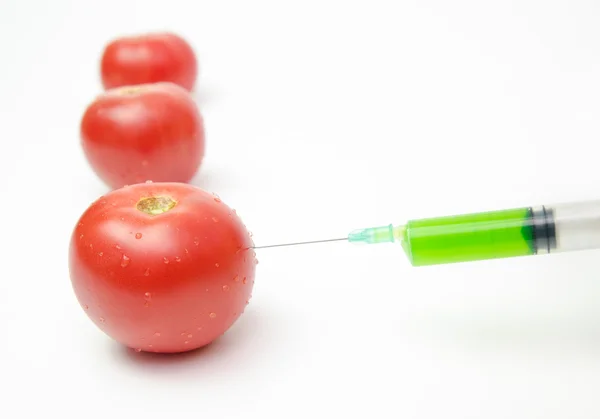 Tomatoes being injected — Stock Photo, Image