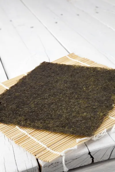 Algues sèches sur un tapis et une table makisu — Photo