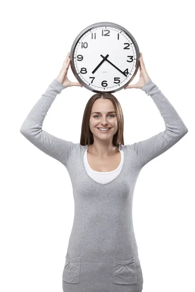 Mujer sonríe con un reloj sobre su cabeza — Foto de Stock