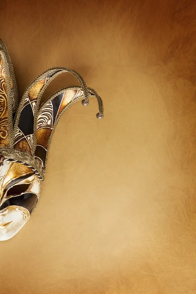 Венецианская маска на текстурированной золотой поверхности — стоковое фото