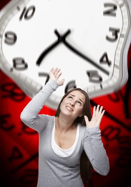 Pressão de tempo em uma mulher com fundo vermelho — Fotografia de Stock