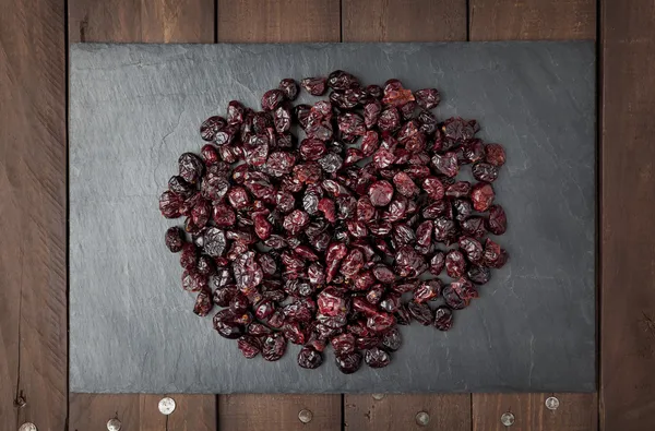 Dry red cranberries on a slate plate — Stock Photo, Image