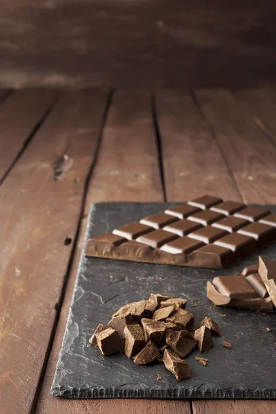 Stücke Schokolade auf Schiefer — Stockfoto