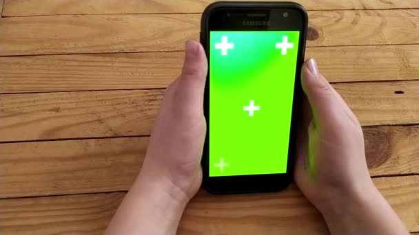 O menino percorre as páginas na Internet em um smartphone com tela verde — Vídeo de Stock