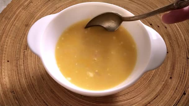 Zuppa con gamberetti in un piatto bianco su un vassoio di legno rotondo. Una donna mescola la zuppa con un cucchiaio — Video Stock