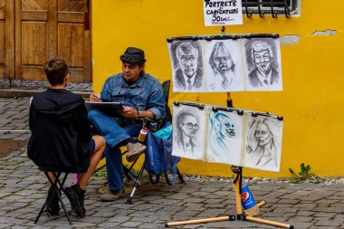 25 Ağustos 2021 'de Romanya' nın Sighisoara sokaklarında bir ressam portreler çiziyor.
