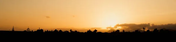 Оранжевый Закат Освещающий Небо Силуэт Зданий Переднем Плане Город Льяроте — стоковое фото
