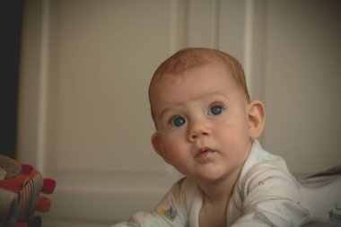 Şaşırmış şirin bebek ve izleyiciye bakıyor.