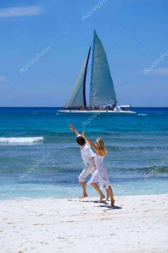 Loving couple runs on a tropical beach