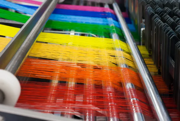 Máquina têxtil com fios de cores do arco-íris — Fotografia de Stock