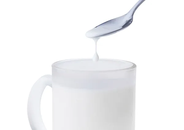 Taza de leche con cuchara —  Fotos de Stock