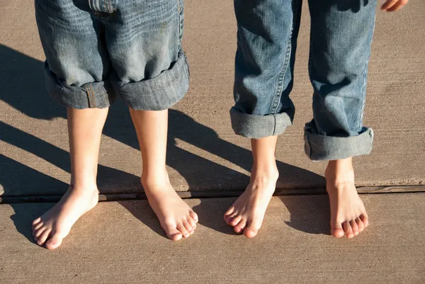 Children with bare feet and pants rolled up — Stock Photo, Image