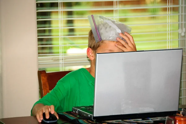 Boy on laptop stressed with headache — Stock Photo, Image