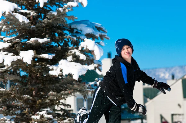 Niño lanzando bola de nieve — Foto de Stock