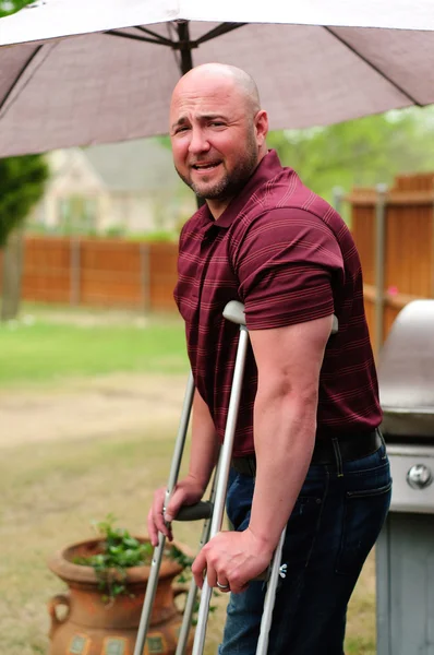 Man op krukken camera kijken — Stockfoto