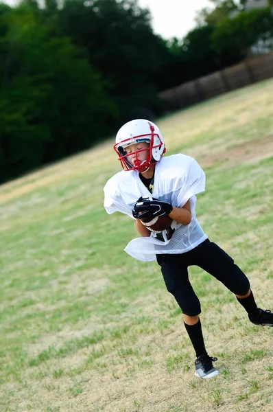 Young football player catching ball — Stock Photo, Image