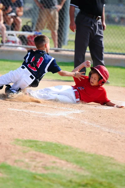 Jogador de beisebol deslizando em home plate — Fotografia de Stock