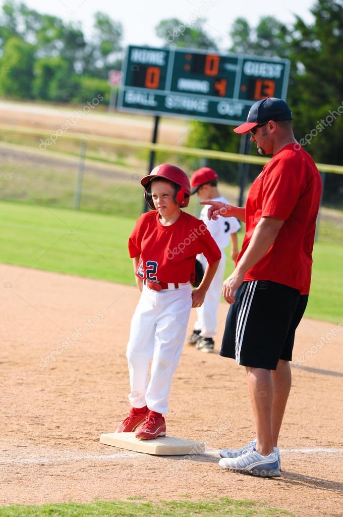Baseball player and baseball coach at first base. Stock Editorial