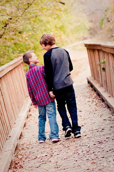 Two boys looking at each other on a bridge — Stock Photo, Image