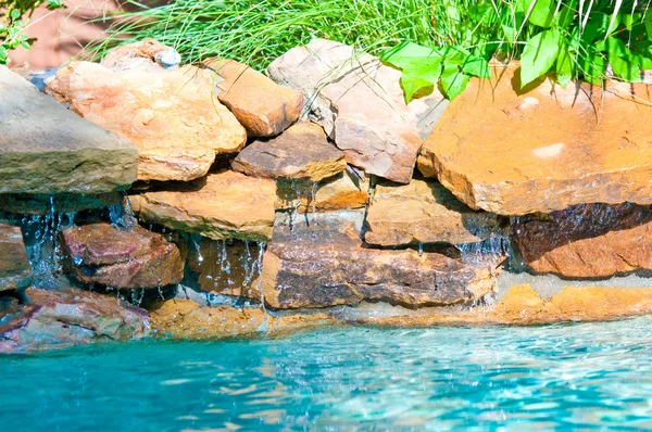 Водопад падает в голубой бассейн — стоковое фото