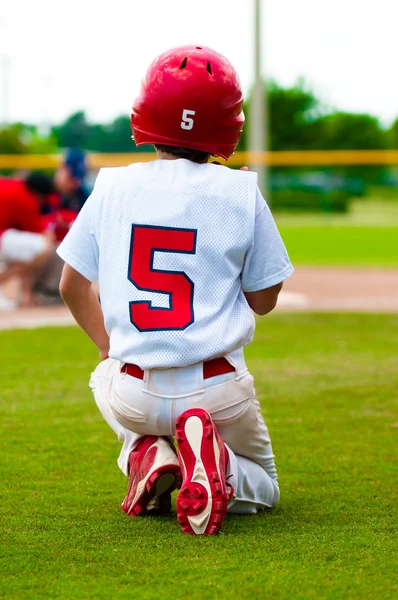Berlutut bocah bisbol untuk pemain yang terluka. — Stok Foto
