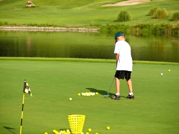 Jonge jongen golfen — Stockfoto