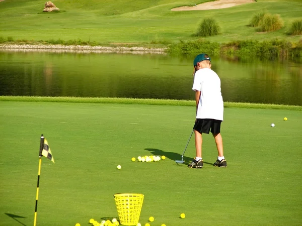 Niño jugando al golf — Foto de Stock